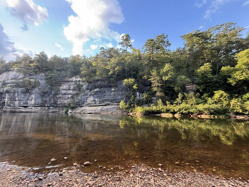 A photo of the Buffalo River, clear with a bluff rising across the river